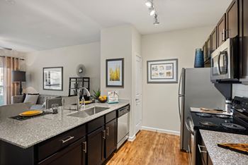A kitchen with a refrigerator, microwave, and oven.